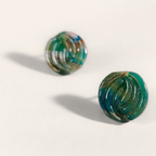 Green marbled round polymer clay studs with parallel curved ridges, angled view