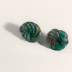 Green marbled round polymer clay studs with spiral ridges, angled view