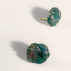 Green marbled round polymer clay studs with spiral ridges, angled view