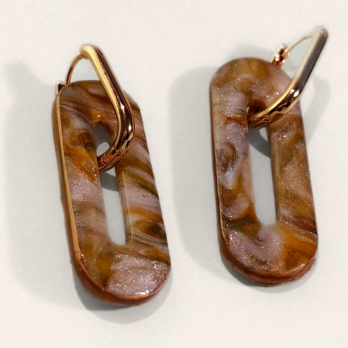 Brown Marble Cut-Out Oblong Hoop Earrings, angled view showing the pattern